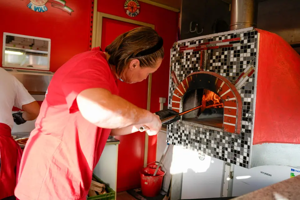 Frische Pizza wird im Holzofen für die Geburtstagsgäste gebacken