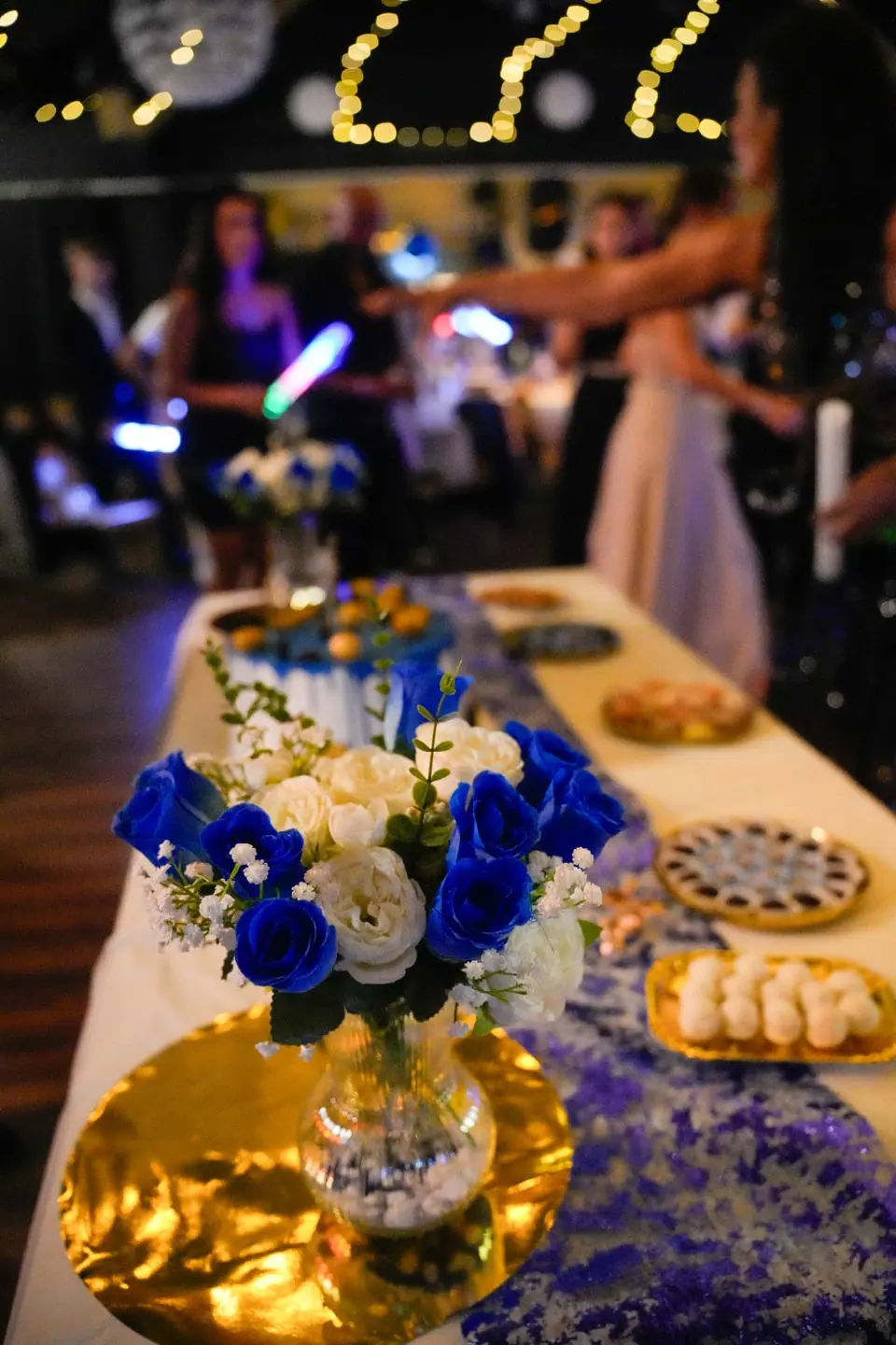Blau-weisser Blumenschmuck vor der feiernden Gesellschaft
