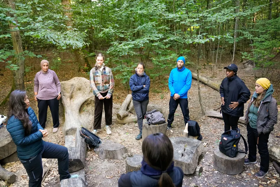 Teilnehmende stehen im Kreis während der Einführung zum Forest Bathing am Käferberg