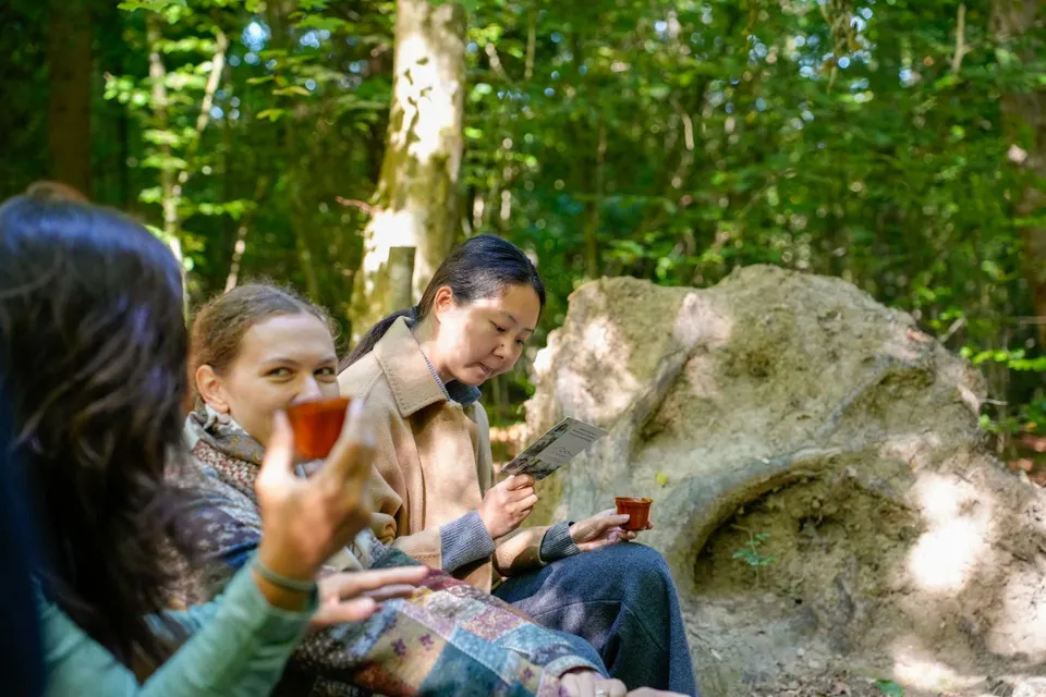 Teilnehmende trinken Tee und lesen die Begleitkarte beim Soundwalk